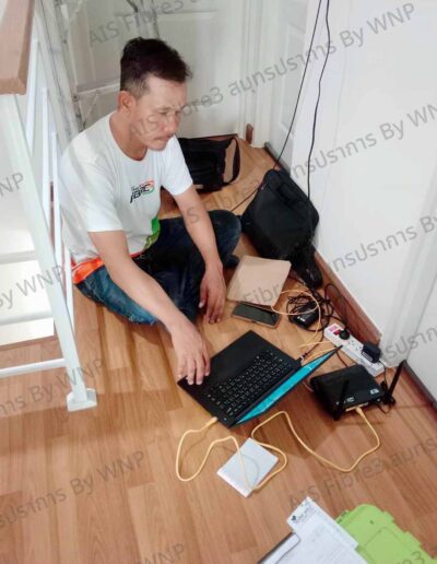 ช่างเทคนิคกำลังติดตั้งเราเตอร์และตั้งค่าเน็ตบ้าน AIS Fibre ภายในบ้านลูกค้า